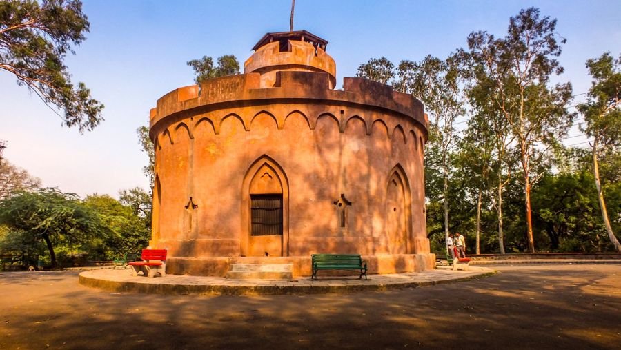 Sandstone tower in a Delhi park, a neighbourhood setting where bike pickups are arranged before the trip to Pune