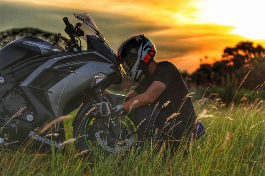 Rider checking a sports bike at sunset before it is transported from Delhi to Ranchi
